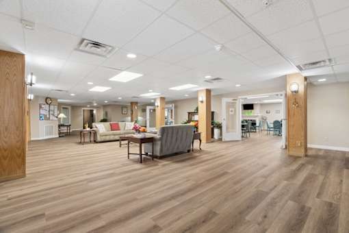 A spacious room with wooden floors and furniture.