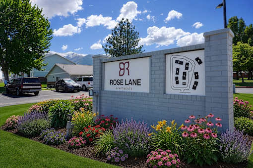 Rose Lane Apartments sign with a landscaped garden in front.