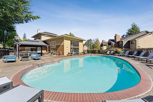 A large outdoor swimming pool surrounded by a brick border.
