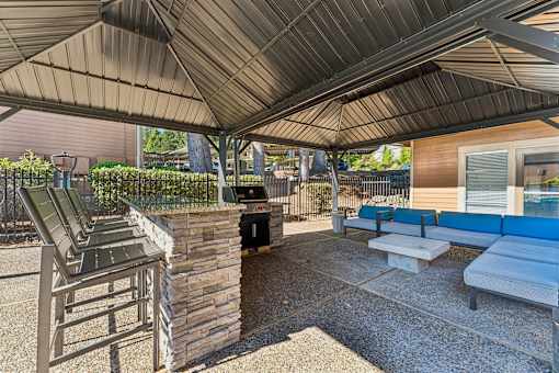 A patio with a stone wall and a metal roof.