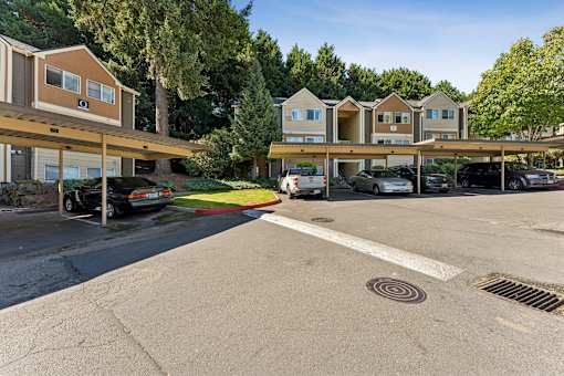 A parking lot with cars and apartment buildings in the background.