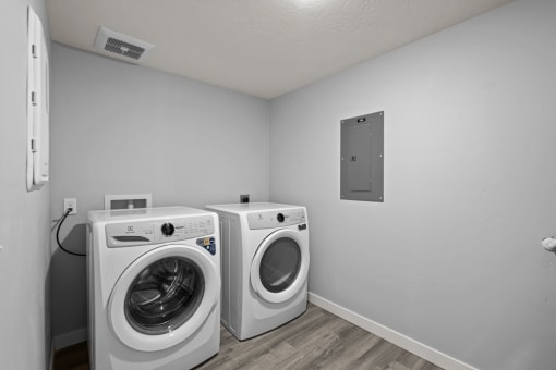 the living room has two washing machines and a washer and dryer