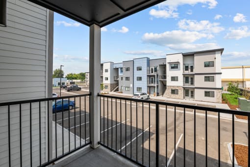 the view from the balcony of an apartment building with a parking lot