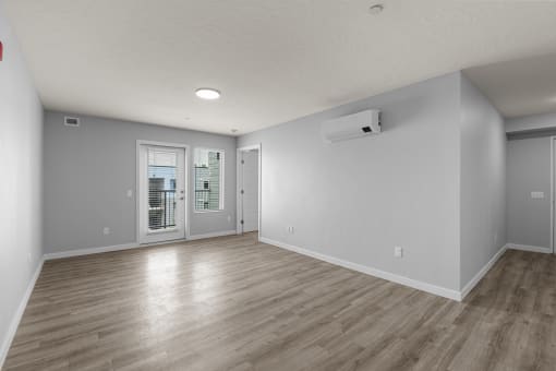 the living room and dining room of an empty house with white walls and wood floors