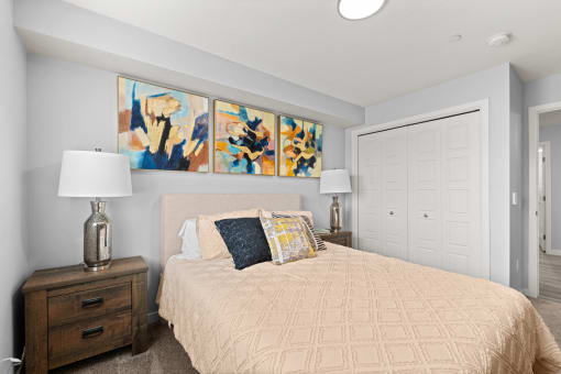 a bedroom with a bed and paintings on the wall