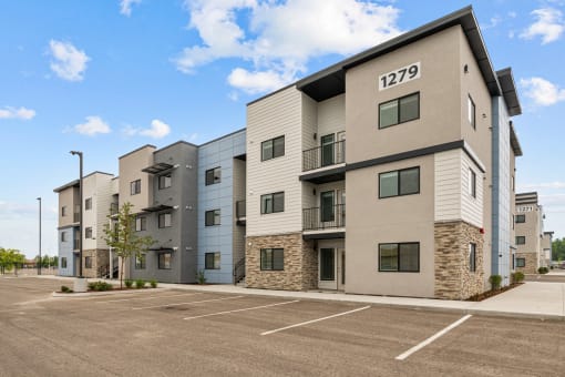 modern apartment buildings with a parking lot and a blue sky