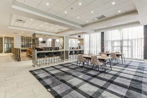 A large room with a checkered floor and tables and chairs.