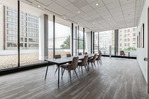 A conference room with a long table and chairs is shown.