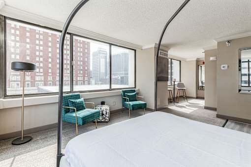 A bedroom with a large bed and a view of the city.