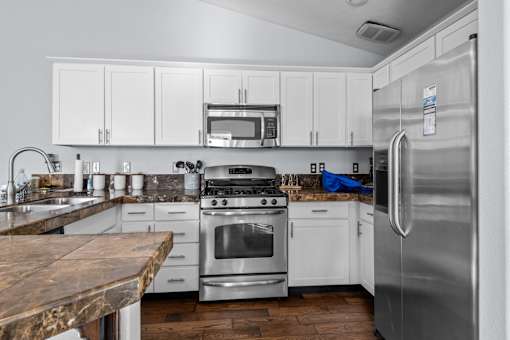 a kitchen with stainless steel appliances and white cabinets