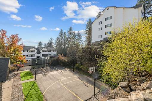 the view of a basketball court with a building in the background