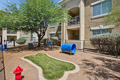 A playground area with a red fire hydrant and a blue slide.