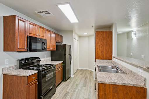 A kitchen with wooden cabinets and black appliances.