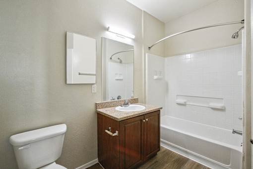 A white toilet sits next to a sink in a bathroom.