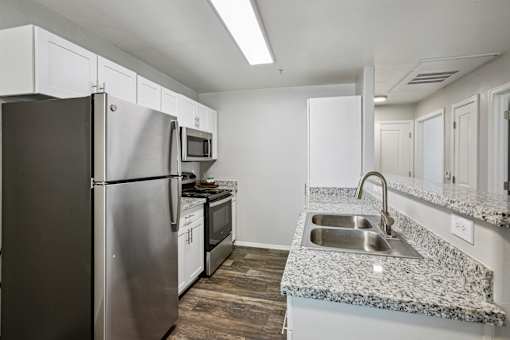 A kitchen with a stainless steel refrigerator, microwave, and oven.