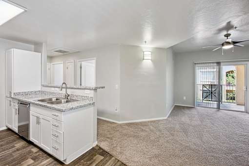 A kitchen with white cabinets and a sink.