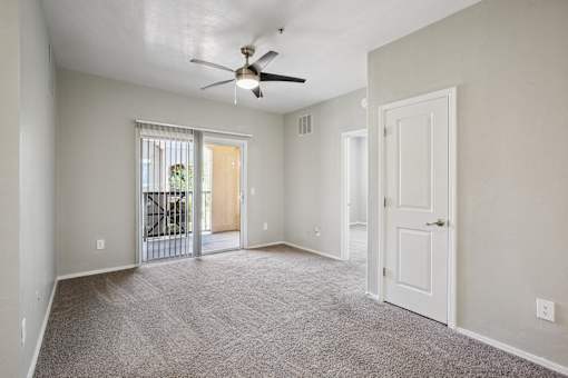 A room with a ceiling fan and carpeted floor.