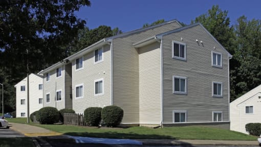 an apartment building with tan siding and a street