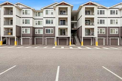 A large parking lot in front of apartment buildings.