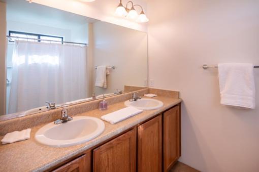 A bathroom with two sinks and a mirror.