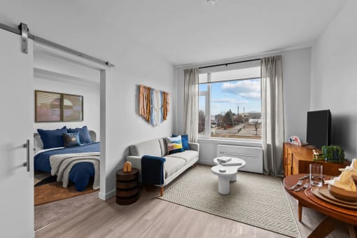 a living room with a couch and a toilet and a window