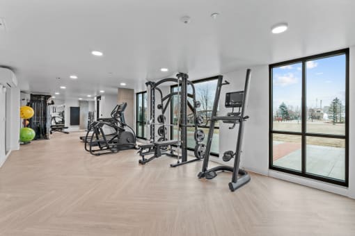 a gym with exercise equipment and large windows