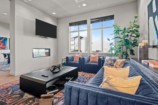 a living room with blue couches and a tv