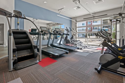 a gym with treadmills and other exercise equipment in a building with a balcony