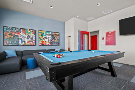 a games room with a pool table and a tv