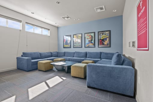 a living room with couches and chairs and posters on the wall