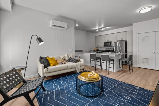 a living room and kitchen with a couch and a table