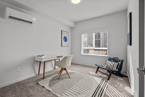 an office space with a desk and a chair and a window