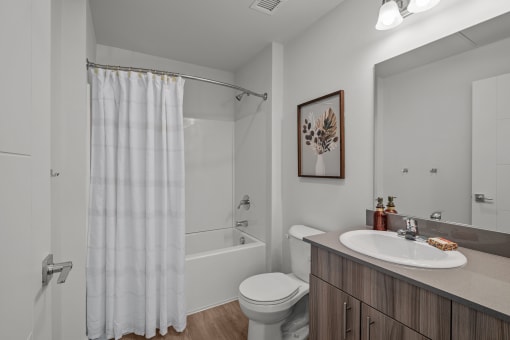 a bathroom with a shower and a sink and a toilet