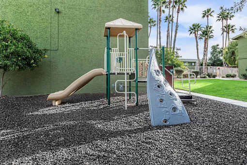 A playground with a slide and a climbing frame.