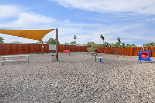 A sandy volleyball court with a net, bench, and ball.