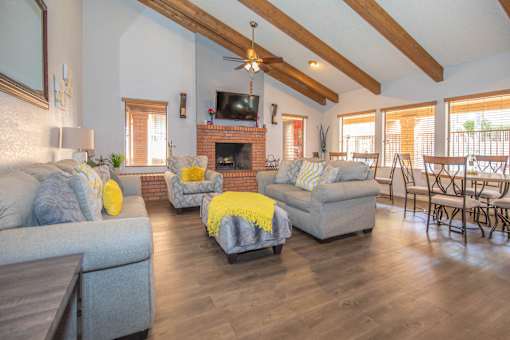 A living room with a grey couch, yellow throw pillows, and a fireplace.