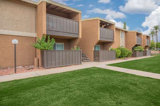 Apartment complex with green lawn in front.
