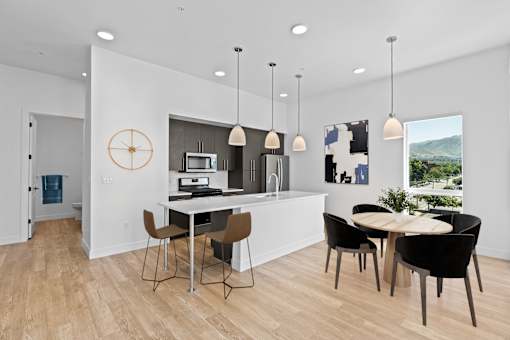 A modern kitchen with a dining table and chairs.