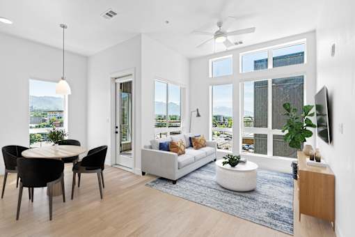 A modern living room with a dining table and chairs.