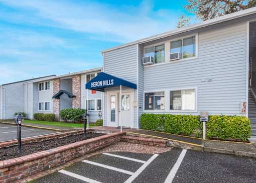 Entryway of building and parking at Heron Hills apartments in Gresham Oregon.