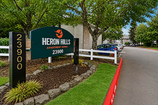 A sign for Heron Hills Apartment Homes with the number 23900 on it.