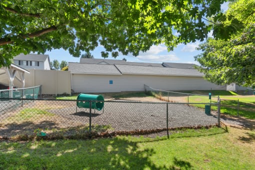 the backyard of a house with a tennis court and a fence
