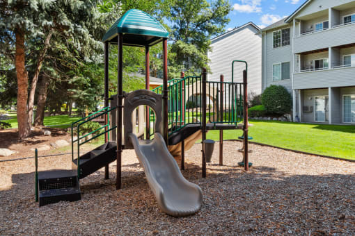 a playground with a slide and monkey bars at the whispering winds apartments in pearland, tx