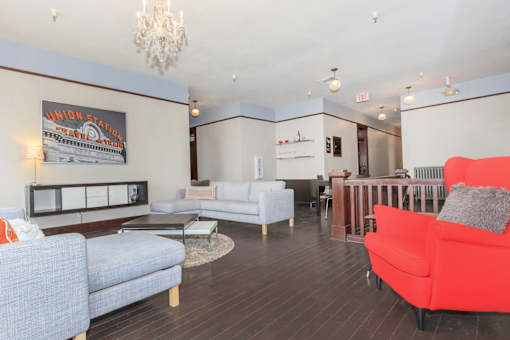 A living room with a grey couch and a red couch.