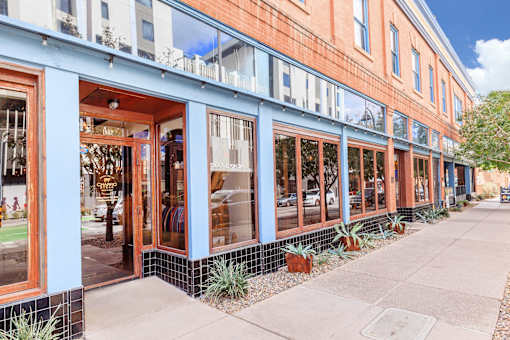 A row of shops with the front one having a red door.