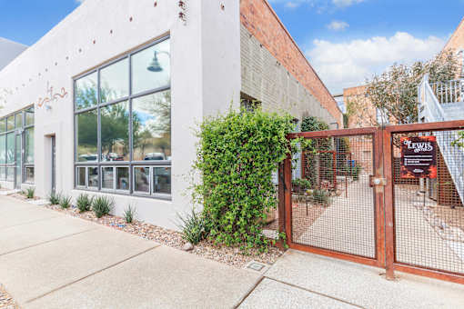 A white building with a red gate and a sign that says "LEWIS".