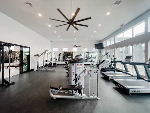 A gym with treadmills, weights, and exercise equipment.