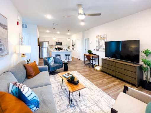 A living room with a grey couch and a wooden coffee table.
