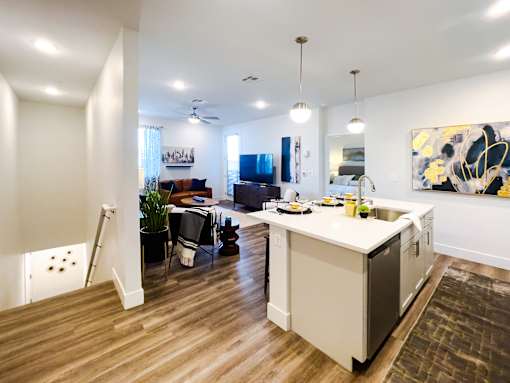A modern kitchen with a wooden floor and white walls.