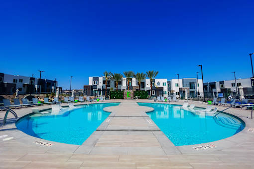 A large outdoor swimming pool with a building in the background.
